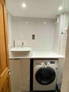 uma cozinha com uma máquina de lavar roupa e um lavatório em Elegant flat in a fantastic area em Londres