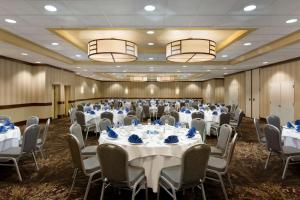 a conference room with tables and chairs with blue napkins at Embassy Suites by Hilton Piscataway Somerset in Piscataway