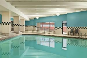 uma grande piscina com paredes e cadeiras azuis em Hilton Garden Inn Saskatoon Downtown em Saskatoon