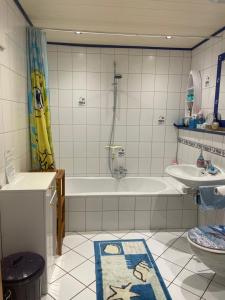 a bathroom with a tub and a sink and a toilet at Feriendomizil Burg in Overath