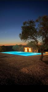 a house with a tree and a swimming pool at night at Agriturismo La Croisette in Dorgali