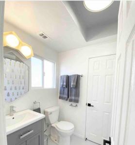 een witte badkamer met een toilet en een wastafel bij Crown Point Home w/ Cowboy Pool 2 Blocks to Bay in San Diego