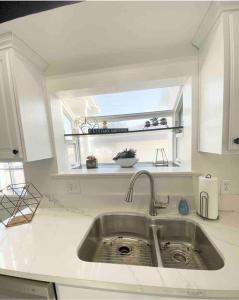 a kitchen counter with a sink and a window at Crown Point Home w/ Cowboy Pool 2 Blocks to Bay in San Diego