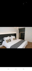 IMHOST Superbe appartement canal de l'Ourcq - la Villette في باريس: غرفة نوم بسرير كبير عليها شراشف ووسائد بيضاء