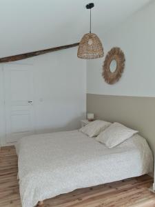 Habitación blanca con cama y espejo en Maison provençale, jardin arboré et terrasses proche Grignan 8-10pers, en Réauville