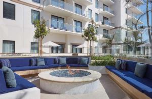 um pátio com sofás azuis e uma fogueira em The Waterfront Beach Resort, A Hilton Hotel em Huntington Beach