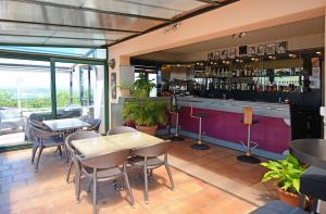 a restaurant with tables and chairs and a bar at Hotel & Restaurant le Saint Jean in Cargèse