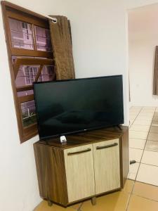 a flat screen tv sitting on top of a wooden cabinet at TuRiStAnDo eM fLoRiPa in Florianópolis