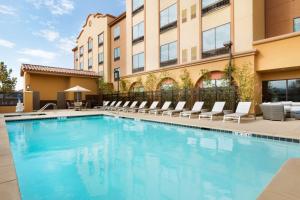 a swimming pool with lounge chairs and a building at Hilton Garden Inn Lompoc, Ca in Lompoc