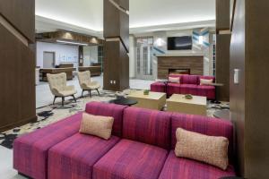 a living room with a pink couch and chairs at Hilton Garden Inn St. Cloud, Mn in Waite Park