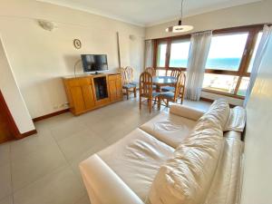 sala de estar con sofá y mesa con TV en Tres ambientes moderno con vista panorámica al mar en Mar del Plata