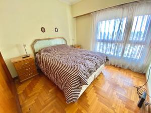 1 dormitorio con 1 cama y suelo de madera en Tres ambientes moderno con vista panorámica al mar en Mar del Plata