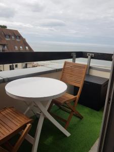 a white table and two chairs on a balcony at Appartement Liza 2 pièces Vue Mer à Cabourg in Cabourg