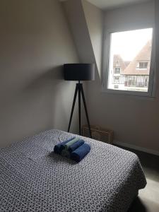 Un dormitorio con una cama con una toalla azul. en Appartement Liza 2 pièces Vue Mer à Cabourg, en Cabourg