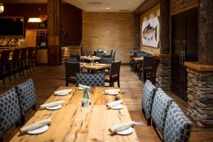 une salle à manger avec des tables et des chaises en bois dans l'établissement Tailwater Lodge Altmar, Tapestry Collection By Hilton, à Pulaski