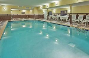 a large swimming pool with tables and chairs at Hampton Inn & Suites Aberdeen in Aberdeen