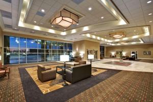 a lobby of a hotel with chairs and tables and windows at Hampton Inn & Suites Aberdeen in Aberdeen