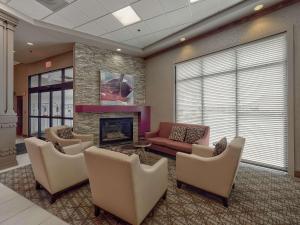 uma sala de estar com um sofá e cadeiras e uma lareira em DoubleTree by Hilton Bloomington em Bloomington