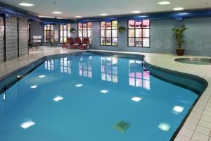 a swimming pool with blue water in a building at DoubleTree by Hilton Bloomington in Bloomington