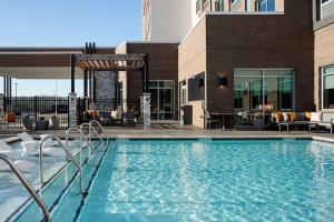 a swimming pool with chairs and a building at Hilton Garden Inn Mt. Juliet, TN in Mount Juliet