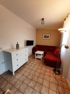 ein Wohnzimmer mit einem roten Sofa und einem TV in der Unterkunft Casa Luna in Donnerskirchen