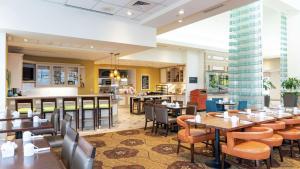 a restaurant with tables and chairs and a bar at Hilton Garden Inn Wooster in Wooster