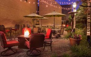 un patio con sillas, mesas y sombrillas en Hilton Chicago/Northbrook, en Northbrook