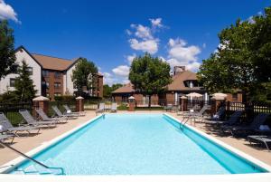 a large swimming pool with chairs and a building at Homewood Suites Dayton-Fairborn in Fairborn