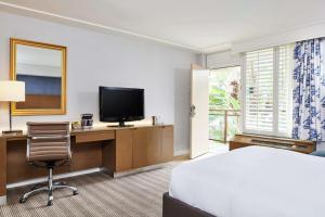 a hotel room with a bed and a desk with a television at DoubleTree by Hilton Torrance - South Bay in Torrance