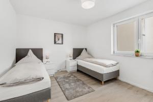 2 bedden in een witte kamer met een raam bij WINETIME - modern - Boxspringbetten - Netflix - Nähe Mercedes-Benz in Wörth am Rhein