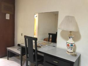 a desk with a lamp and a mirror at Hotel las hamacas in Acapulco
