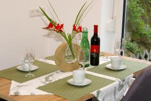 a table with a vase of flowers and wine bottles at Sellraintaler Auszeit 1 in Sellrain