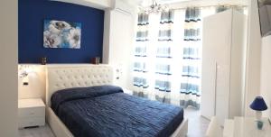 a bedroom with blue walls and a bed with blue sheets at B&B Crystal in Messina