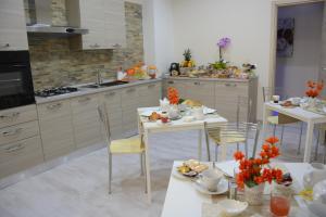 a kitchen with two tables and chairs with food on them at B&B Crystal in Messina