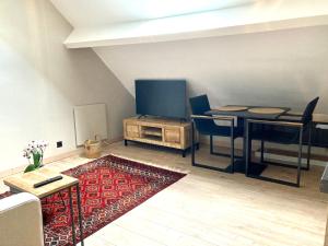 ein Wohnzimmer mit einem Tisch und einem Flachbild-TV in der Unterkunft Chez Roya in Zaventem