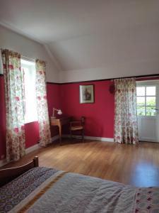 - une chambre avec des murs rouges, un lit et un bureau dans l'établissement Les Glycines, à Vulaines-sur-Seine