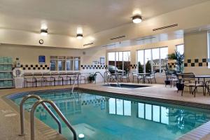 a pool in a hotel with tables and chairs at Hilton Garden Inn Minneapolis Eagan in Eagan