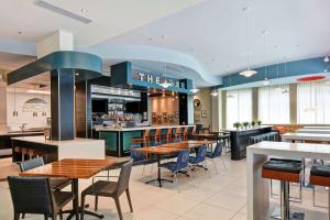 a restaurant with tables and chairs and a bar at Hilton Garden Inn Raleigh/Crabtree Valley in Raleigh