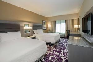 a hotel room with two beds and a flat screen tv at Hilton Garden Inn Raleigh/Crabtree Valley in Raleigh