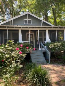 uma casa cinzenta com flores cor-de-rosa à frente. em Southern Comfort em Tallahassee