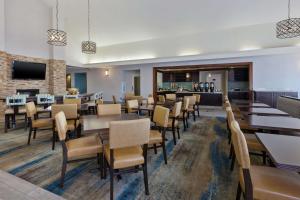 um restaurante com mesas e cadeiras e um bar em Homewood Suites by Hilton Chesapeake - Greenbrier em Chesapeake
