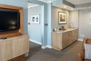 a hotel room with a flat screen tv and a bar at DoubleTree by Hilton Pittsburgh-Green Tree in Pittsburgh