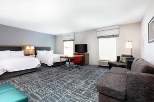 a hotel room with two beds and a couch at Hampton Inn Acworth in Acworth