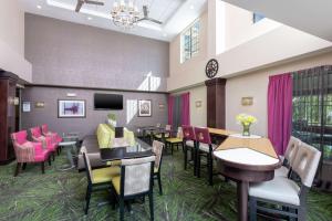 una sala de espera con mesas, sillas y TV en Homewood Suites by Hilton Columbus/Polaris, en Columbus