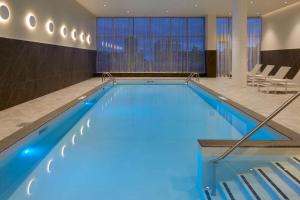 een groot zwembad met blauw water in een hotelkamer bij Hilton Garden Inn Montreal Midtown, Quebec, Canada in Montreal