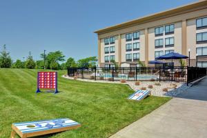 a hotel with two play equipment in the grass at Hampton Inn Cincinnati Airport South in Florence