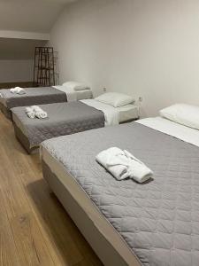 Habitación con 3 camas y toallas blancas. en Struga Apartments, en Struga