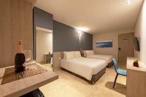 Habitación de hotel con cama y botella de vino en HOTEL RILUX CARTAGENA, en Cartagena de Indias