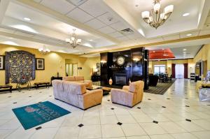 a lobby with two chairs and a fireplace at Homewood Suites by Hilton Tulsa-South in Broken Arrow