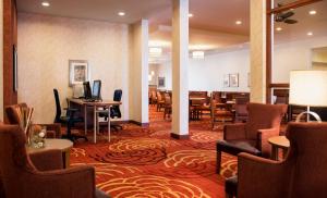 a hotel lobby with a restaurant with tables and chairs at Homewood Suites by Hilton Winnipeg Airport - Polo Park in Winnipeg